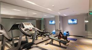 ein Fitnessstudio mit mehreren Cardiogeräten in einem Raum in der Unterkunft Echarm Hotel Guilin Railway Station the MixC in Guilin