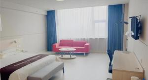 een kamer met een bed, een bank en een tv bij Jinjiang Inn Hengshui Anping in Anping