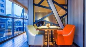 a restaurant with orange and white chairs and a window at Echarm Hotel Guiyang Qianling Mountain in Guiyang