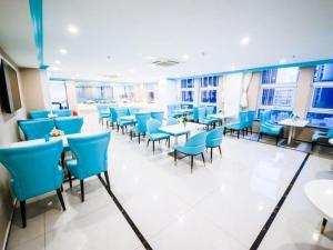 een eetkamer met blauwe stoelen en tafels bij Xana Hotelle Jinan Wuanfu Interchange Huafu International Square in Jinan