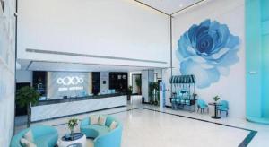 een grote lobby met een blauwe bloem aan de muur bij Xana Hotelle Jinan Wuanfu Interchange Huafu International Square in Jinan