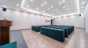 una habitación con mesas verdes y sillas. en IU Hotel Chongqing Airport T3 Terminal, en Chongqing