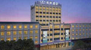a large building with a sign on top of it at Xana Hotelle Zhongshan Bus Terminal Fuhuang Road Tianyuecheng in Changzhou