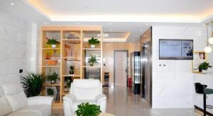 a lobby with white furniture and plants in a building at Green Tree Inn Express Xingtai Guangzong Development Zone Xingqing Road in Guangzong