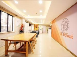 a dining room with a table and a kitchen at Shell Hotel Shanghai Expo Changqing Road Metro Station in Shanghai