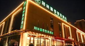 a building with neon signs on the side of it at GreenTree Inn Express Datong High-Speed Railway Station Wanda Plaza Fangte in Shuiposhi