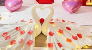 twee zwanen in de vorm van harten liggen op een bed bij Thank Inn Guizhou Bijie Qianxi County High-Speed Railway Station in Qianxi