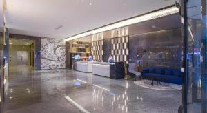 a lobby with a blue couch and a bar at Echarm Hotel Nanning the MixC Dongmeng Business District in Nanning