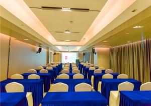 een conferentiezaal met blauwe tafels en witte stoelen bij Echarm Hotel Qujing High-speed Railway Station 1st Wuguan Center in Qujing