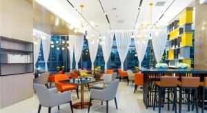 een restaurant met oranje en witte stoelen en tafels bij Echarm Hotel Qujing High-speed Railway Station 1st Wuguan Center in Qujing