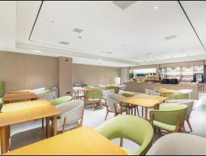 a classroom with tables and chairs and a cafeteria at JI Hotel Shanghai International Tourism Resort Chongxi Road in Nanhui
