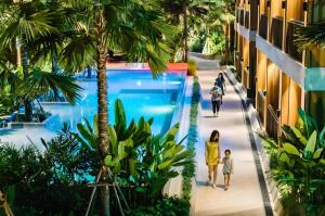 een groep mensen die over een loopbrug lopen in een resort bij Riverton Hotel in Samut Songkhram