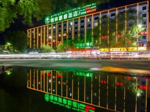 a building at night with its reflection in the water at Green Tree Inn Tibet Lhasa Zhaji Temple in Lhasa
