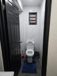 a bathroom with a white toilet and a black door at Raiwai homestay in Suva +12 photos