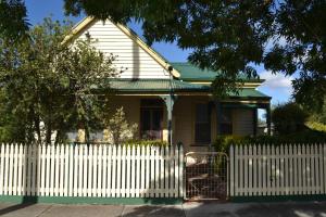 a white picket fence in front of a house at Maison D'aurum in Nerrina