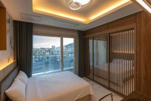 a bedroom with a bed and a large window at New CZ Nampo Hotel in Busan