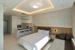 a bedroom with a large bed and a couch at New CZ Nampo Hotel in Busan