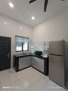 a kitchen with a refrigerator and a counter top at Mersing little homestay II in Mersing