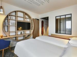 a hotel room with a bed and a tv at ibis Styles La Roche-sur-Yon in Mouilleron-le-Captif