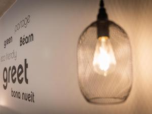 een gloeilamp die aan een muur hangt met een bordje bij Greet Hôtel Orthez Bearn in Orthez +74 foto's