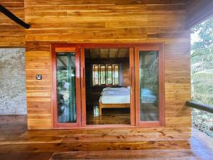 een kamer met een raam in een houten huis bij Cocoa Home in Ban Ko Phrao