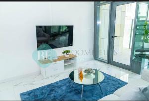 uma sala de estar com uma mesa e uma TV em 2 Br Luxury duplex Canal View, 5 min to AUH Airport, Yas island , Raha Mall em Abu Dhabi