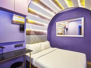 a purple room with a bed and a mirror at ibis budget Singapore Mount Faber in Singapore