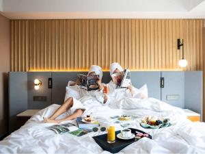 Dos personas acostadas en la cama con platos de comida. en Mondrian Seoul Itaewon, en Seúl 212 fotos más