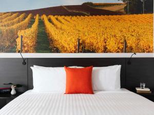 デボンポートにあるNovotel Devonportのブドウ園の絵が飾られたベッドのある寝室 +125枚の写真