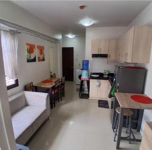 a living room with a couch and a table and a kitchen at Brookridge Suites in Cebu City