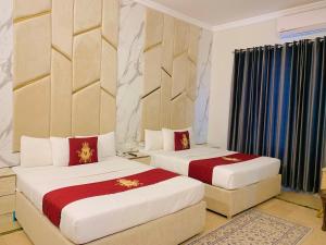two beds in a hotel room with two beds sidx sidx sidx at Hayat Grand Guest House in Islamabad
