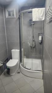 a bathroom with a toilet and a glass shower at Baku Khatai Central Hotel in Baku