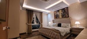 a bedroom with a large bed and a window at Goldcrest Luxury Apartments in Lahore