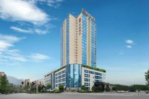 a tall building with a lot of windows at Echeng Hotel Enshi Minzu Road in Enshi