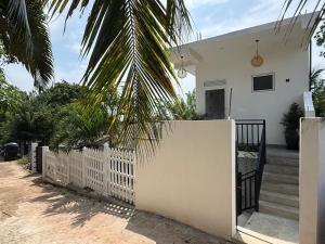 a white fence in front of a white house at Seaview Mountain Villa in Mirissa