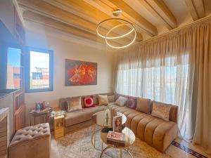 un salon avec un canapé et une table dans l'établissement Palmeraie chic à 10 mn du stade Piscine et confort, à Dar Caïd Layadi