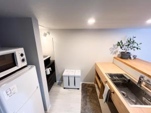 a kitchen with a white refrigerator and a microwave at Rino-Haku 02 in Anan