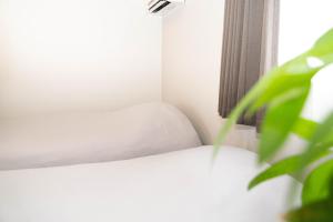a white bed in a room with a window at Rino-Haku 02 in Anan