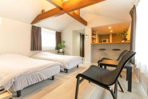 a room with two beds and a chair in it at Rino-Haku 02 in Anan