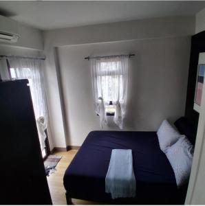 a bedroom with a blue bed and two windows at Brookridge Suites in Cebu City +36 photos