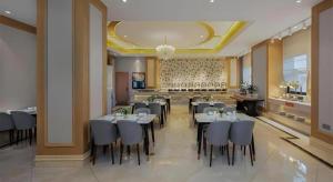 Un comedor con mesas y sillas en un restaurante. en Vienna Hotel Shaanxi Hanzhong Central Square High-Speed Railway Station, en Hanzhong