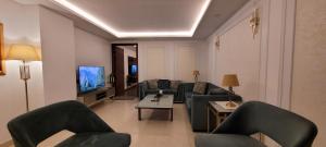 a living room with couches and a tv at Goldcrest Luxury Apartments in Lahore