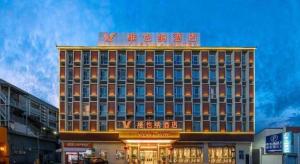 een hotelgebouw met een bord erop bij Vienna Hotel Baoshan Yongchang Road in Baoshan