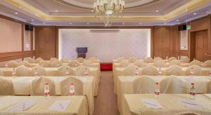 a banquet hall with white tables and chairs and a chandelier at Vienna Hotel Shanghai Hongqiao National Exhibition Center Fengxi Beiqing Road in Fengxi