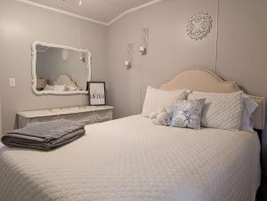 a bedroom with a large white bed with a mirror at Rough River Lake Cabin Fishing in Fentress McMahan