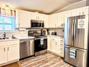a kitchen with white cabinets and a stainless steel refrigerator at Rough River Lake Cabin Fishing in Fentress McMahan
