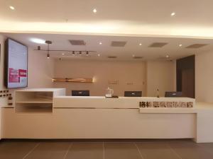 een lobby met een witte bar in een gebouw bij Green Tree Inn Liaoning Shenfu New District in Mantangmanzuxiang