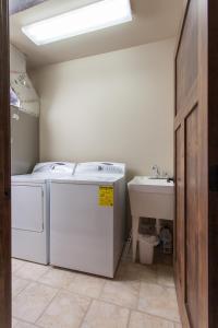 uma lavandaria com uma máquina de lavar roupa e um lavatório em Family-Friendly Cabin Rental with Mountain Vistas near West Glacier, Montana em West Glacier