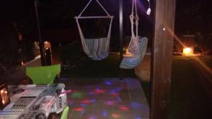 a table and chairs with swings on a patio at night at Kalogirou Stone House in Limnionas +176 photos