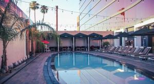 a swimming pool with chairs and umbrellas on a building at Ahern Hotel and Event Center in Las Vegas